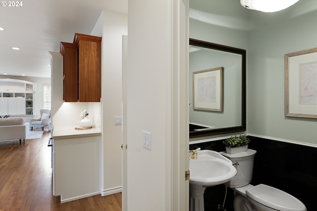 bathroom with toilet, hardwood / wood-style floors, and sink