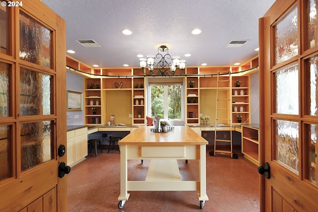 office area with a notable chandelier, a textured ceiling, and light colored carpet