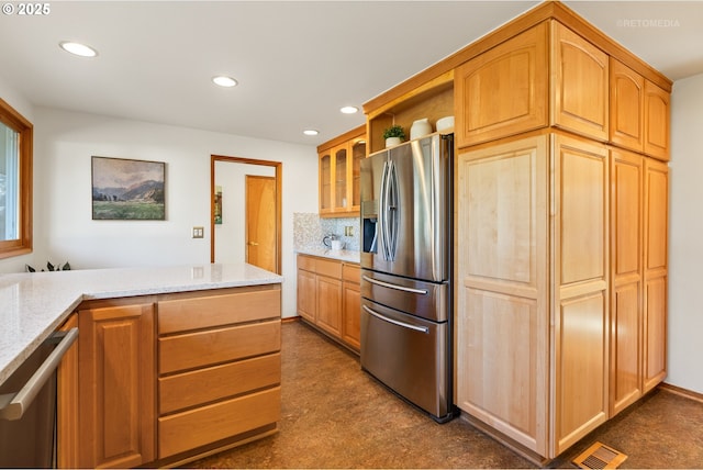 kitchen with tasteful backsplash, light stone countertops, and appliances with stainless steel finishes