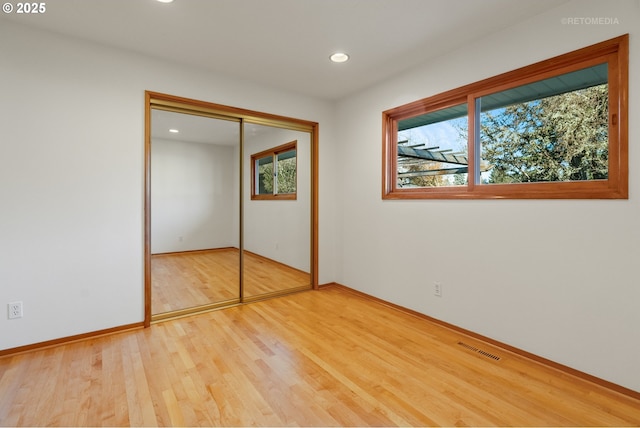 unfurnished bedroom featuring light wood-type flooring and a closet