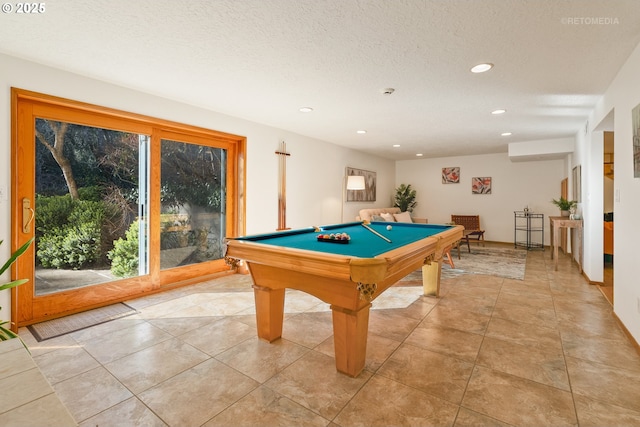 game room with pool table, a textured ceiling, and light tile patterned floors