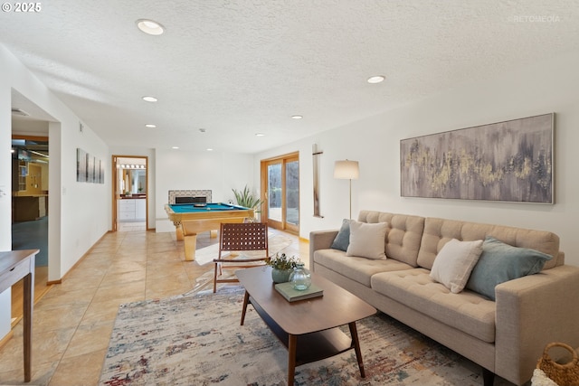 living room featuring light tile patterned floors, pool table, and a textured ceiling