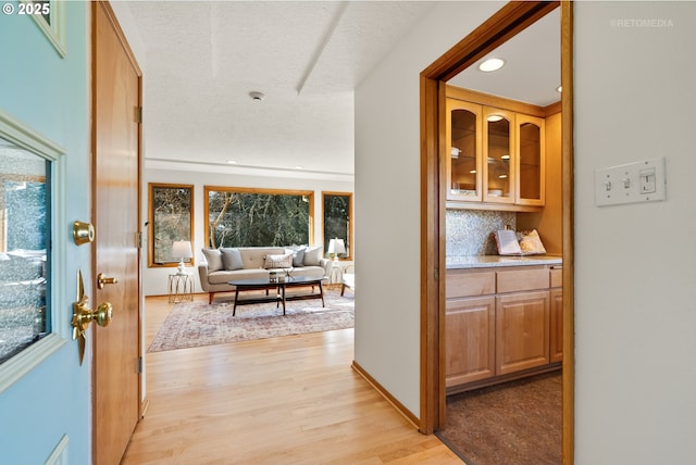 hallway with a textured ceiling and light wood-type flooring