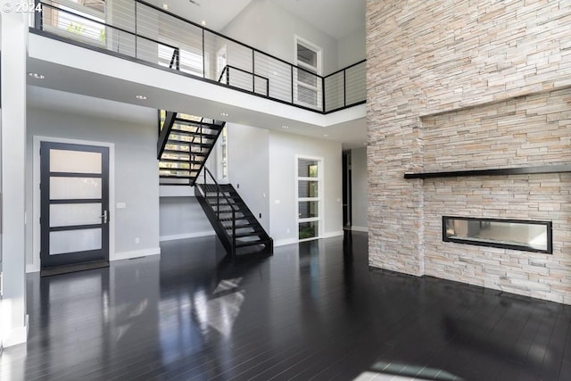 3425 NW Fairway Heights Dr, Bend, OR 97703 - foyer entrance with a fireplace, a towering ceiling, stairs, baseboards, and wood finished floors