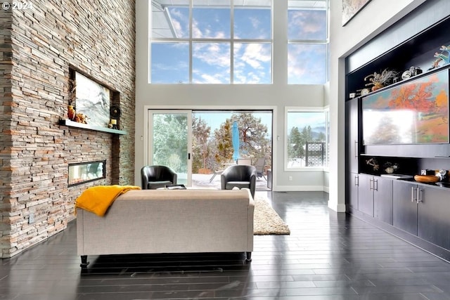 3425 NW Fairway Heights Dr, Bend, OR 97703 - living room with a towering ceiling, dark wood-style floors, plenty of natural light, baseboards, and a fireplace