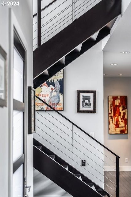 stairs with baseboards, plenty of natural light, and wood finished floors