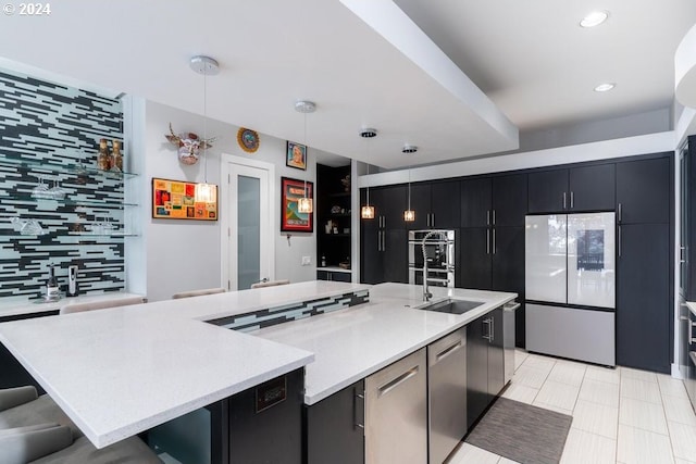 3425 NW Fairway Heights Dr, Bend, OR 97703 - kitchen with stainless steel appliances, a sink, tasteful backsplash, dark cabinetry, and a breakfast bar
