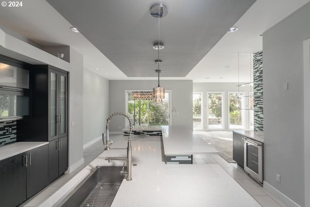 exercise area with a tray ceiling, recessed lighting, beverage cooler, and a healthy amount of sunlight