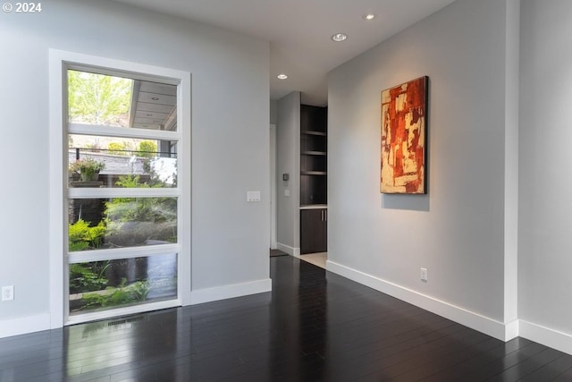 spare room featuring dark wood finished floors, recessed lighting, and baseboards