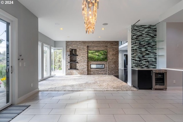 unfurnished living room with recessed lighting, beverage cooler, baseboards, and a chandelier