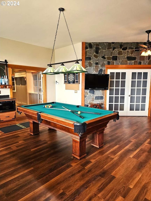 game room featuring billiards, hardwood / wood-style floors, ceiling fan, and a stone fireplace