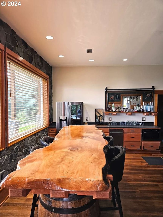 dining room featuring bar and dark hardwood / wood-style flooring