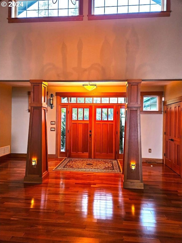 entrance foyer featuring dark wood-type flooring and a towering ceiling