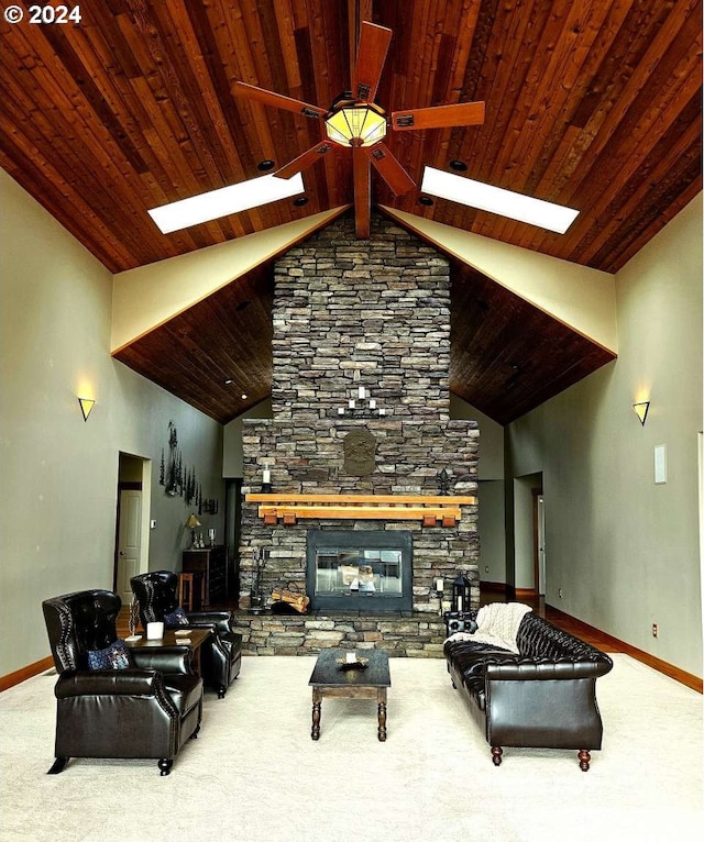 living room featuring a fireplace, carpet, ceiling fan, and a skylight