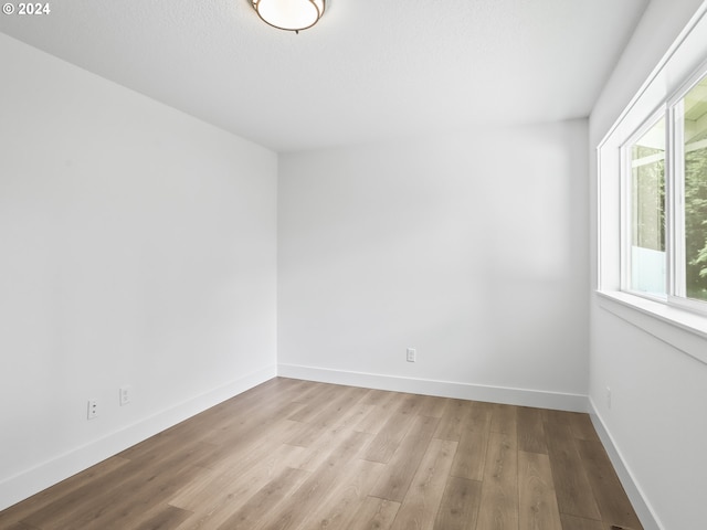 spare room featuring a textured ceiling and light wood-type flooring