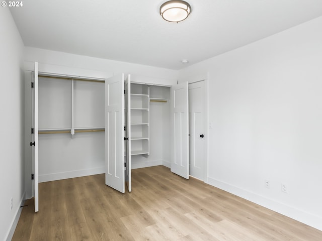 unfurnished bedroom featuring light hardwood / wood-style floors and multiple closets