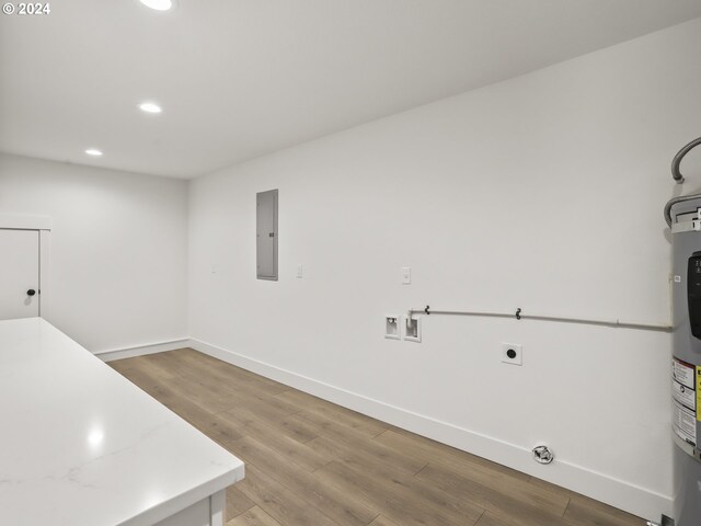 clothes washing area featuring electric dryer hookup, washer hookup, light hardwood / wood-style floors, and electric panel