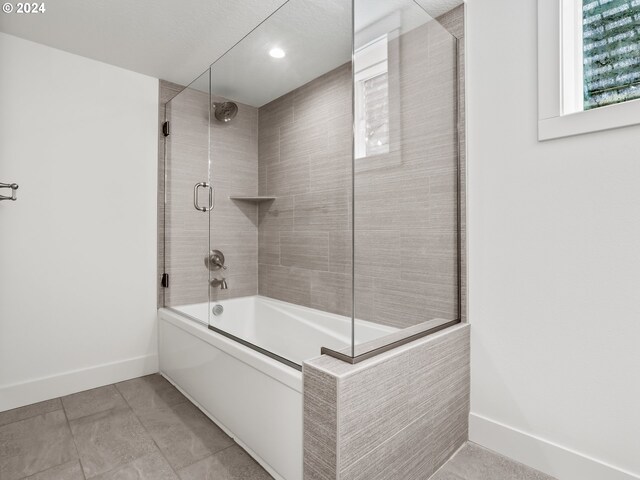 bathroom featuring tile patterned floors and shower / bath combination with glass door