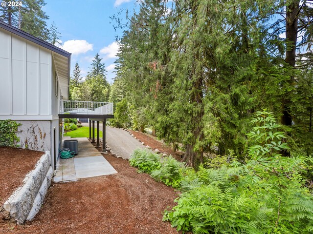 view of yard with central AC and a deck