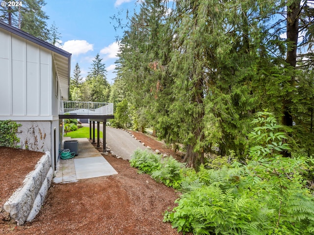 view of yard featuring central AC and a deck