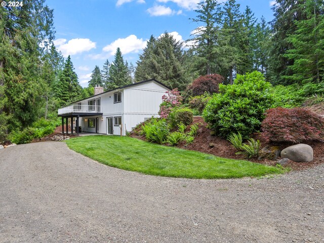 view of front facade with a wooden deck and a front lawn