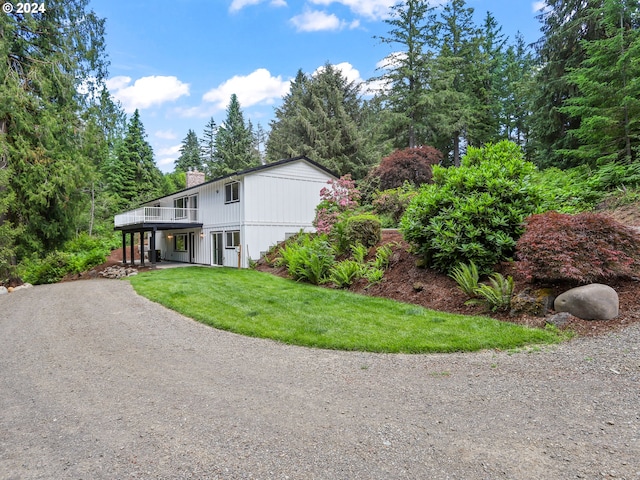 exterior space with a wooden deck and a front yard