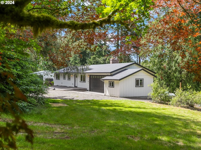 rear view of house with a garage and a lawn