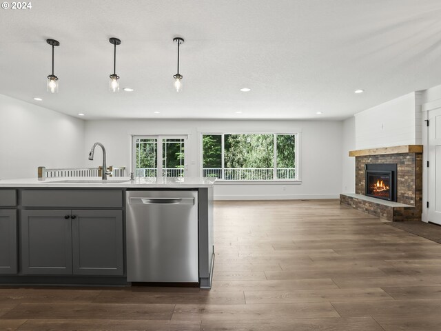 kitchen featuring sink, gray cabinetry, decorative light fixtures, stainless steel dishwasher, and dark hardwood / wood-style floors