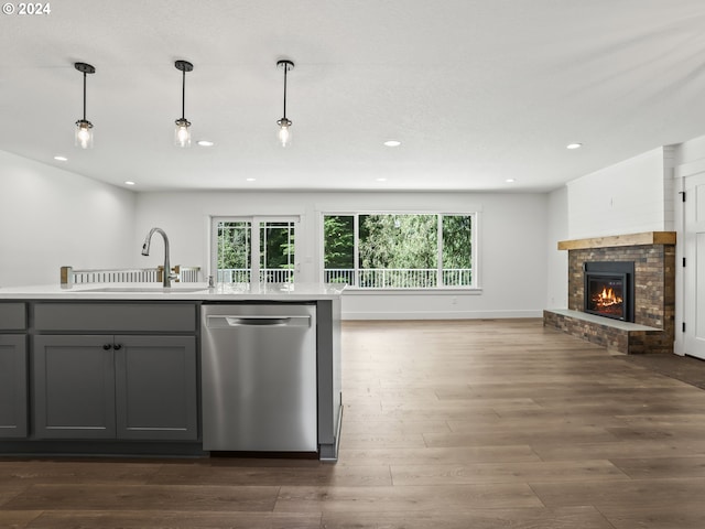 kitchen featuring gray cabinets, decorative light fixtures, dishwasher, sink, and dark hardwood / wood-style flooring