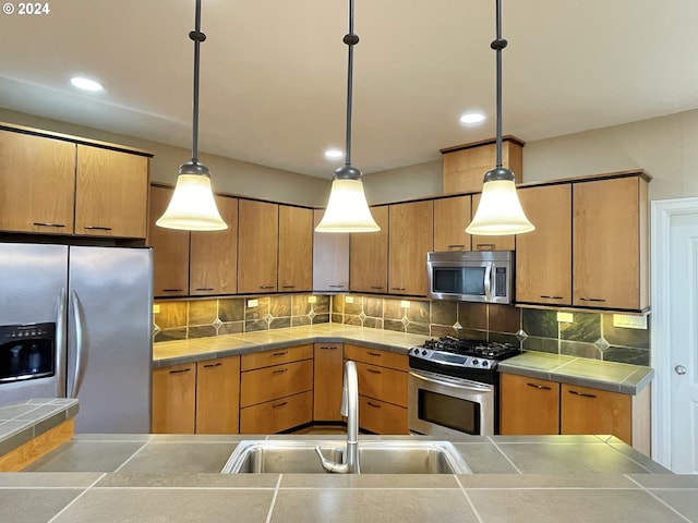 kitchen with stainless steel appliances, sink, hanging light fixtures, and backsplash