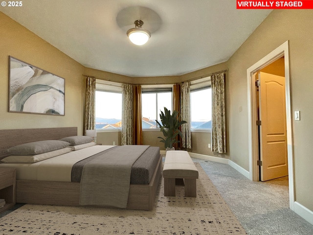 bedroom featuring light carpet and a mountain view