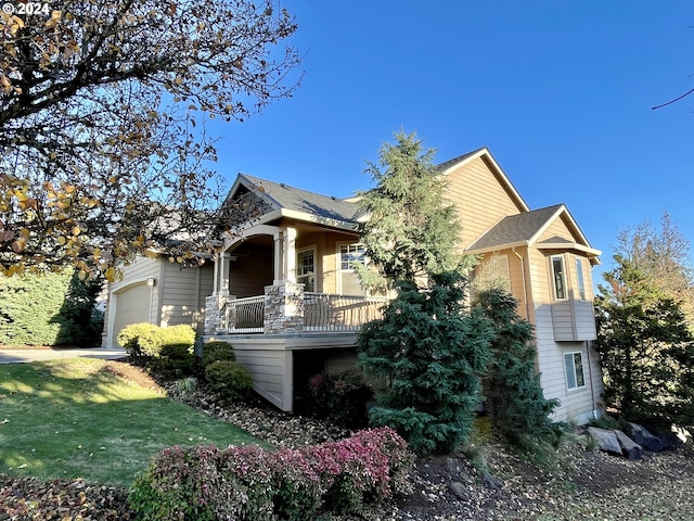 view of front of house featuring a garage, a front yard, and covered porch