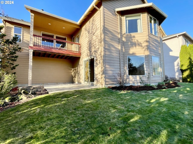 back of house with a lawn, a patio, and a balcony