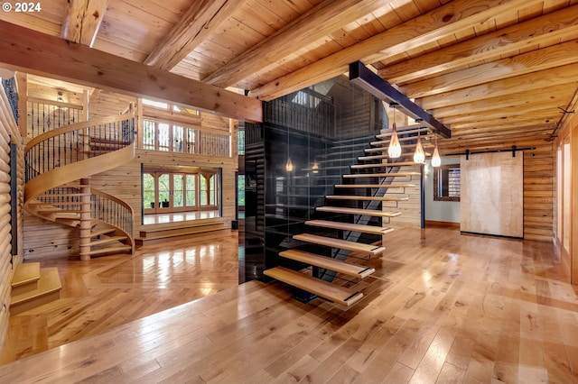 staircase featuring a barn door, wooden ceiling, hardwood / wood-style floors, and beam ceiling