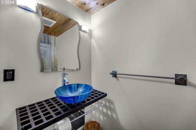 bathroom featuring wood ceiling and sink