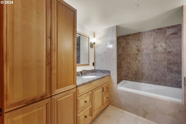 bathroom featuring a relaxing tiled tub, vanity, tile walls, and tile patterned flooring