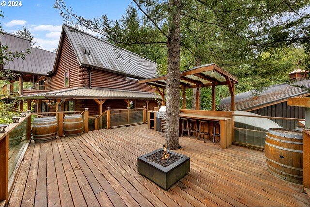 deck featuring an outdoor fire pit and an outdoor bar