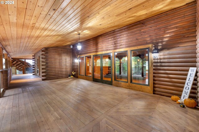 interior space with log walls, plenty of natural light, wood ceiling, and hardwood / wood-style flooring