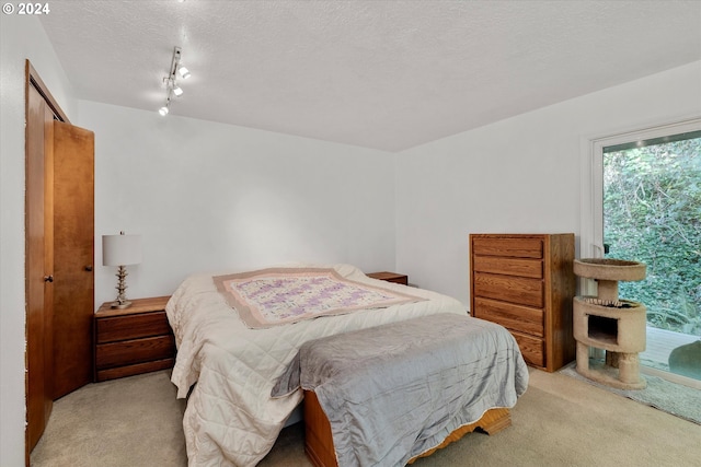 carpeted bedroom featuring a closet and a textured ceiling