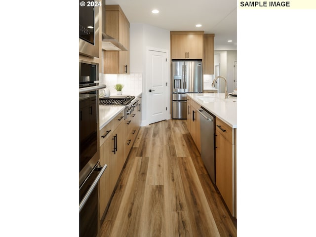 3603 N 12th Cir, Ridgefield, WA 98642 - kitchen featuring appliances with stainless steel finishes, a sink, light wood finished floors, light countertops, and tasteful backsplash