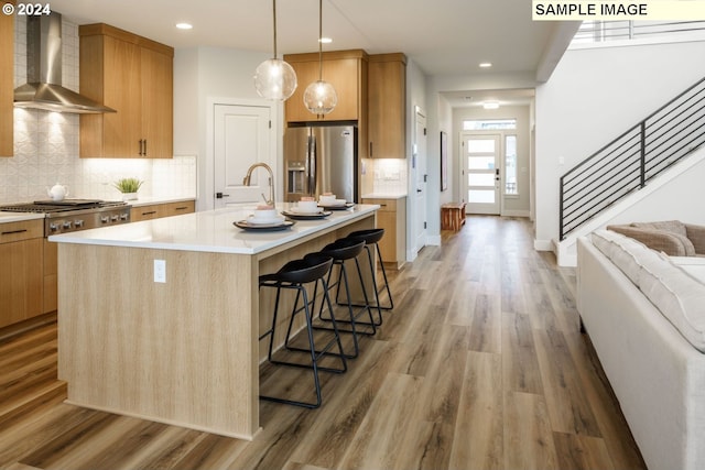 3603 N 12th Cir, Ridgefield, WA 98642 - kitchen with appliances with stainless steel finishes, wall chimney range hood, a sink, light wood finished floors, and recessed lighting