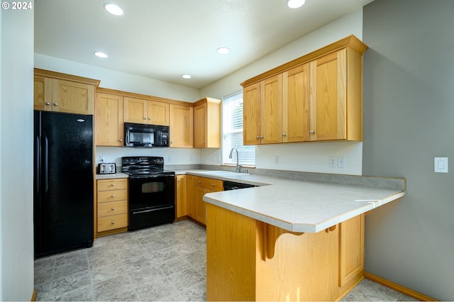 kitchen with black appliances, a breakfast bar, kitchen peninsula, and sink