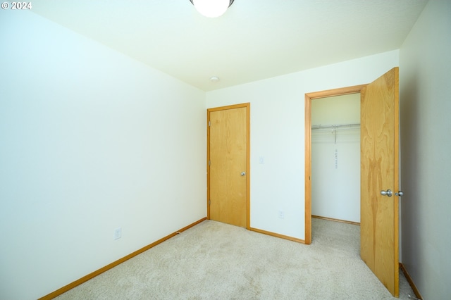 unfurnished bedroom with a closet and light carpet