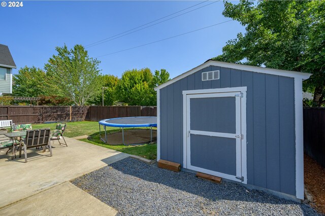 view of outbuilding featuring a yard and a trampoline