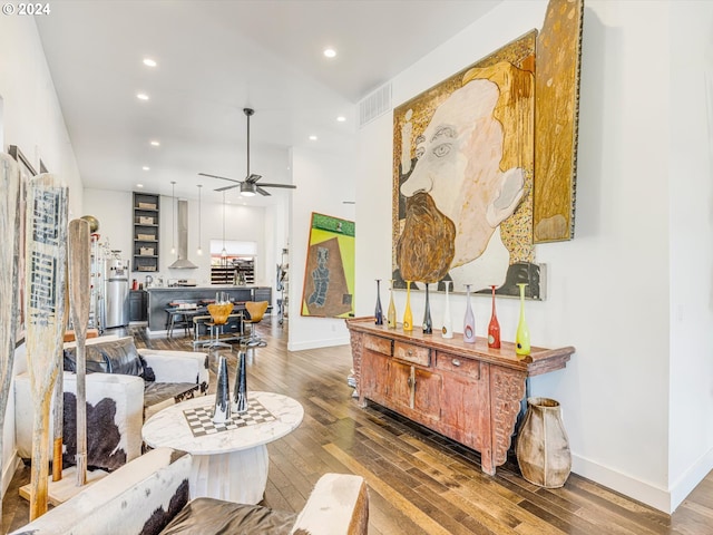 living area with recessed lighting, visible vents, wood-type flooring, and baseboards