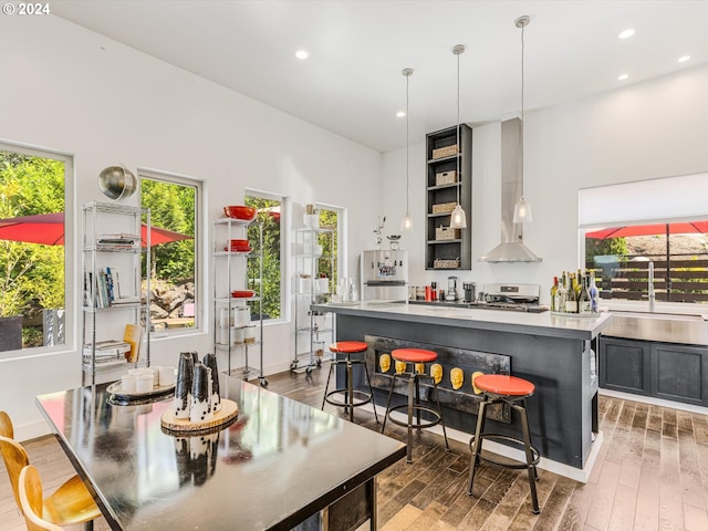 dining room featuring recessed lighting, light wood-style flooring, a bar, and baseboards