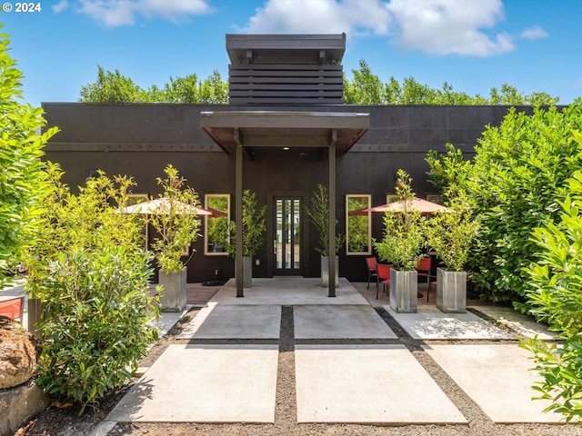 property entrance featuring french doors, a patio area, and stucco siding