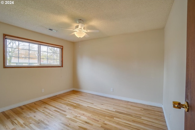 spare room featuring a textured ceiling, ceiling fan, and light hardwood / wood-style flooring