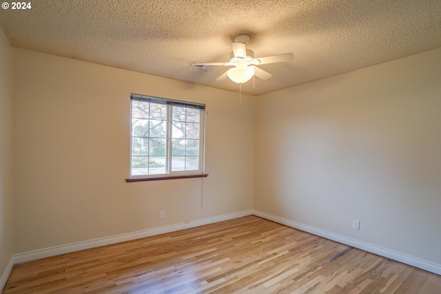 spare room with a textured ceiling, ceiling fan, and light hardwood / wood-style floors