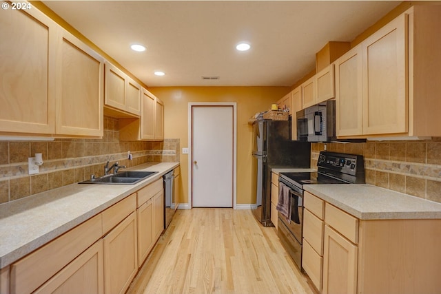 kitchen with dishwasher, light brown cabinetry, light hardwood / wood-style floors, electric range, and sink